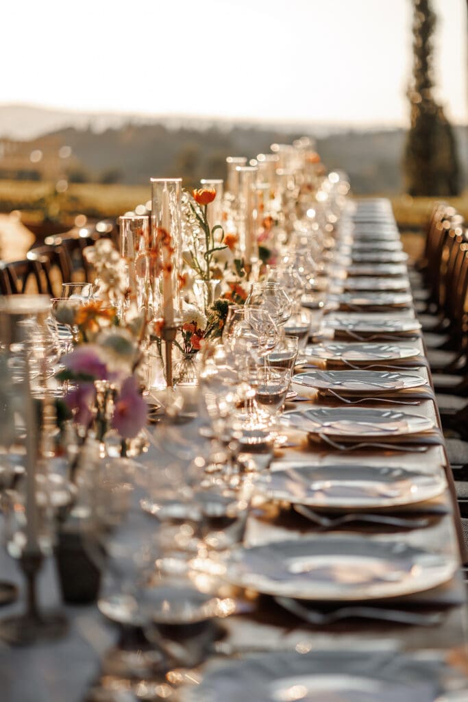 Close detail of the reception table at golden hour with tapered candles and blush florals