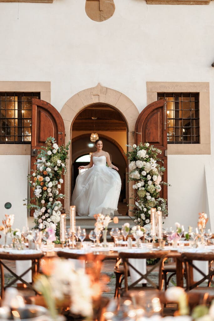 reception-floral-arch-tenuta-di-sticciano.jpgBride Hannah stepping through the flower-adorned arched doorway into the reception
