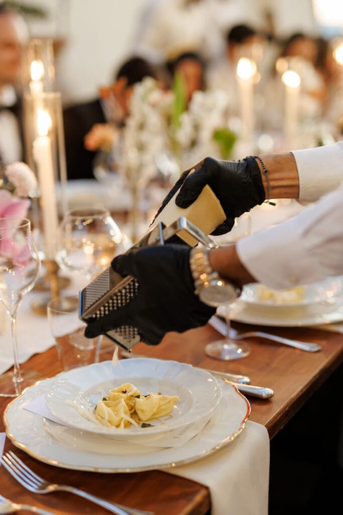 Kitchen Wishes catering staff grating fresh truffle over cacio e pepe at the wedding dinner at Tenuta di Sticciano, Tuscany