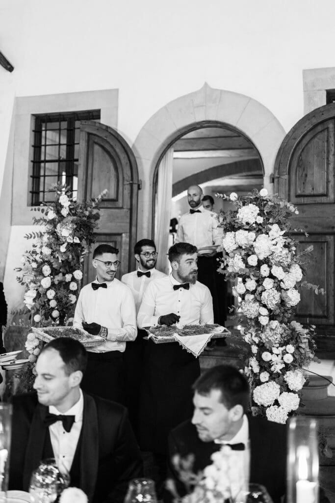 Kitchen Wishes waiters carrying trays through the arched doorway, black and white