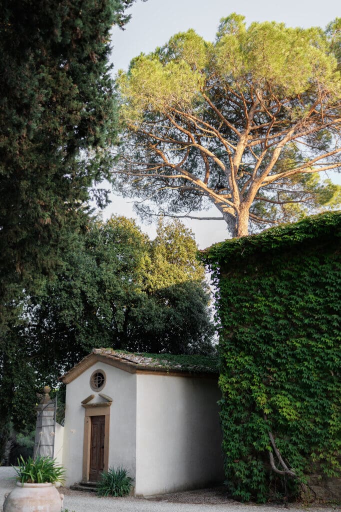 Small stone chapel and ivy-covered wall in the gardens of Tenuta di Sticciano, a wedding venue near Certaldo in Tuscany